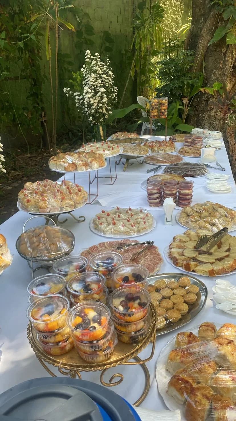 Mesa externa com salgados, frutas e doces
